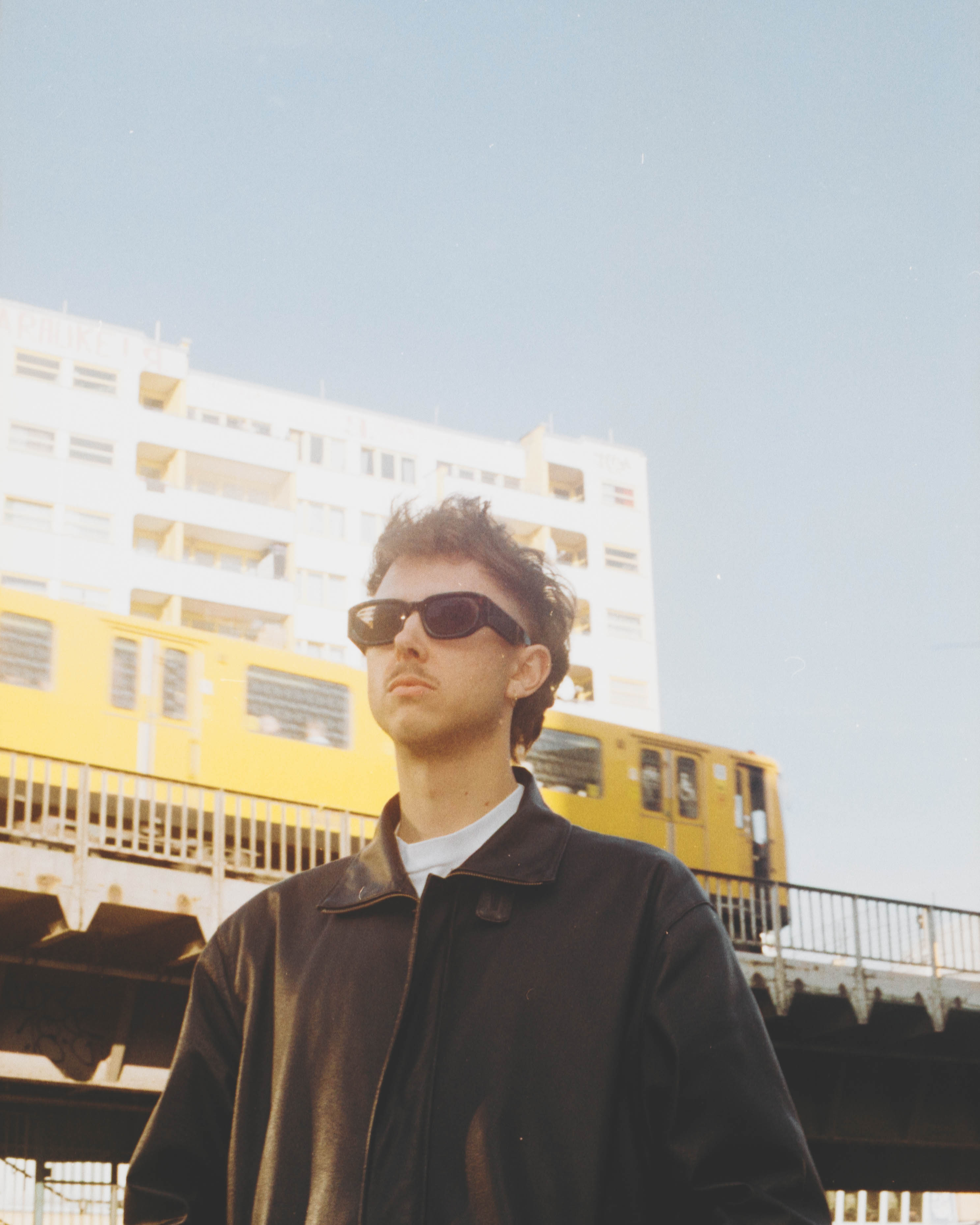 Erik Lindberg, photographer, standing beneath an elevated U-Bahn line